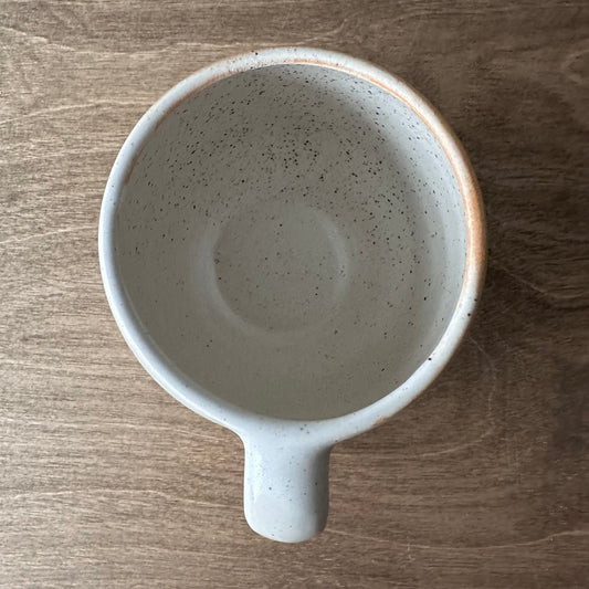 Speckled ceramic mug on a wooden surface