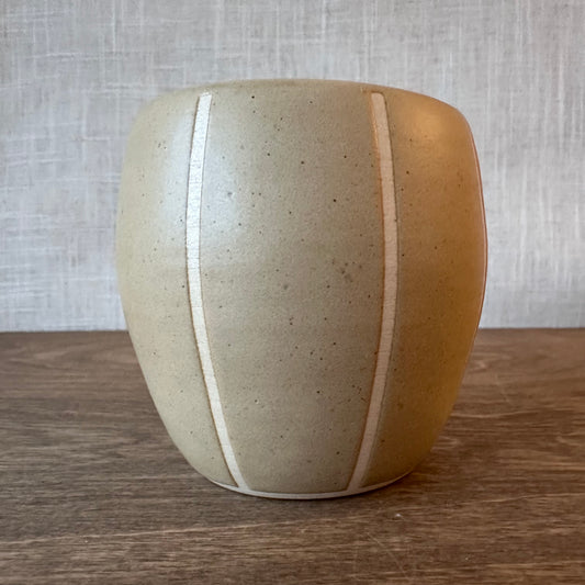Ceramic vase with two-tone design on a wooden surface