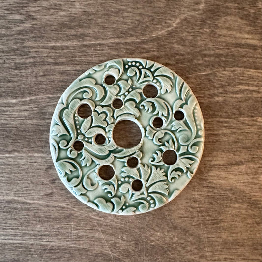 Decorative circular object with intricate patterns on a wooden surface
